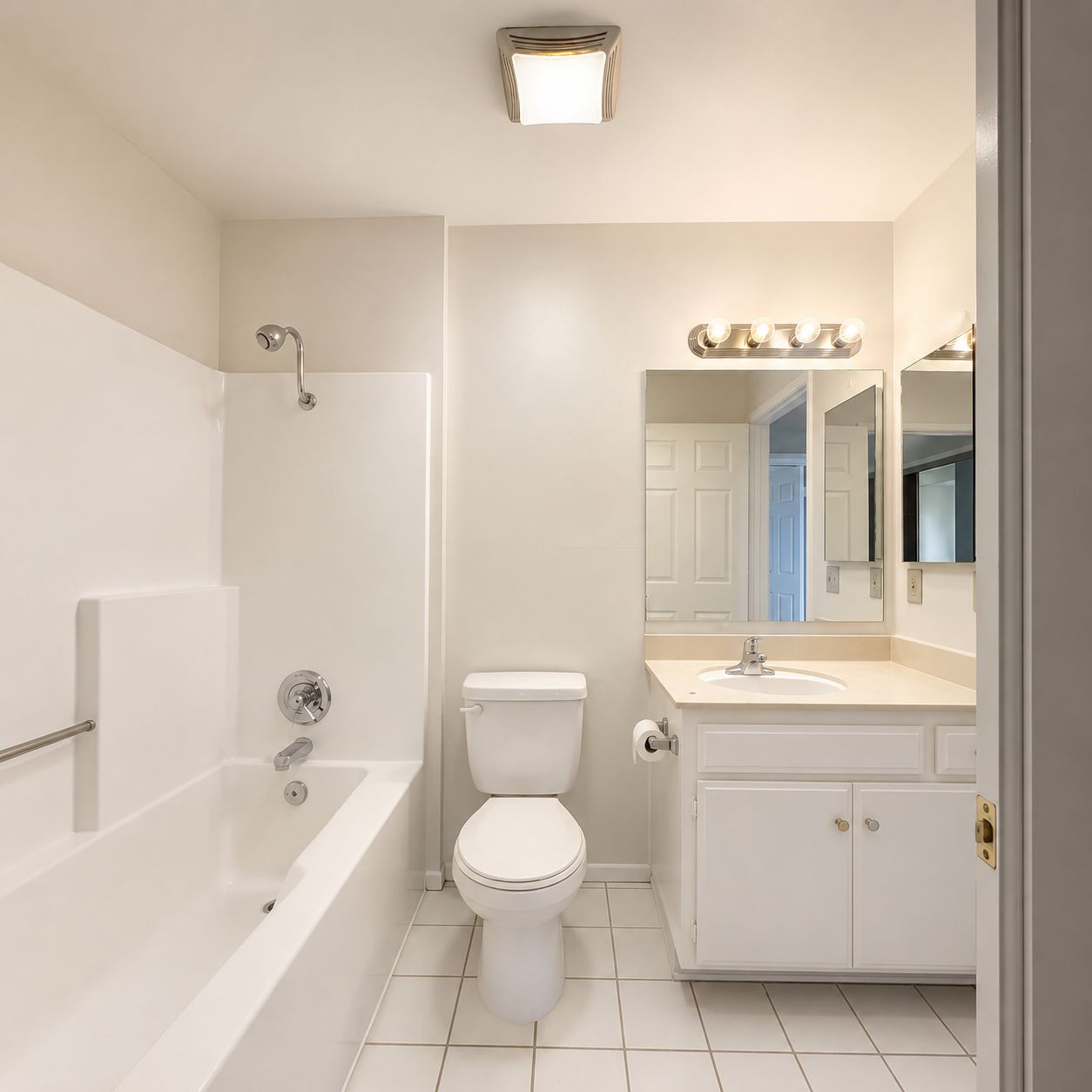 Bright bathroom with tub, vanity, and tile floor